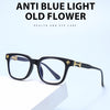 A pair of black, square anti blue light glasses resting on a white surface.