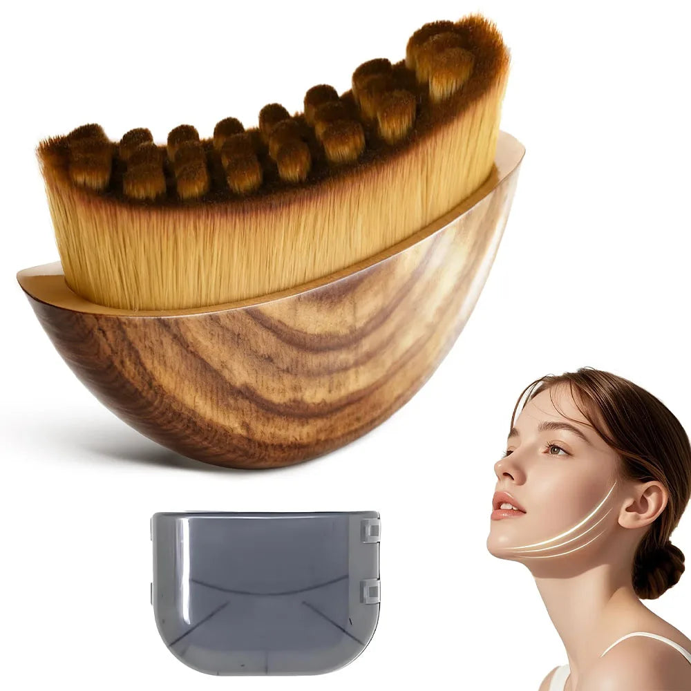A golden face brush with brown bristles rests in a wooden storage case next to a gray silicone tool.
