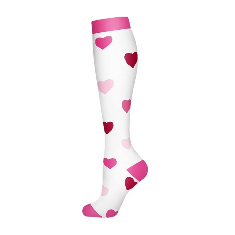 A pair of white compression socks with pink heart patterns.