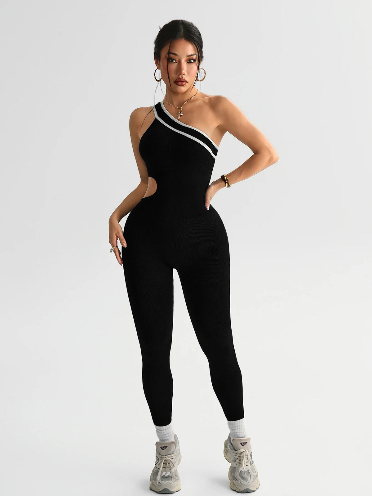 A model wearing a black seamless yoga jumpsuit with a white stripe detail.