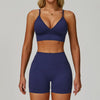Eine Frau modelliert eines dunkelblaues, nahtloses Sport-Yoga-Set mit Crop-Top und passenden Shorts.