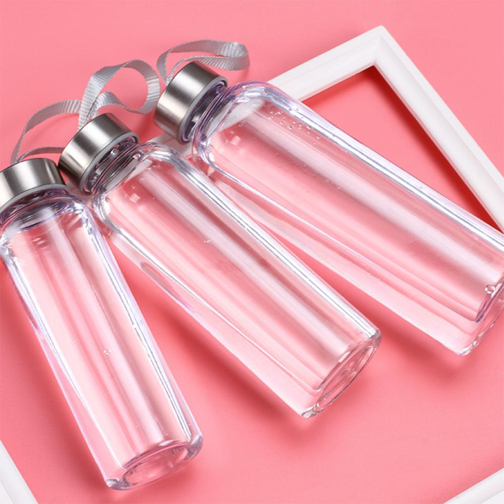 Trois bouteilles d'eau sport en plastique transparent avec des bouchons argentés sont présentées sur un fond rose.