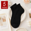 Five pairs of black breathable mesh lace tube socks displayed on a white plate.