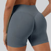 A close-up shot of a woman wearing seamless high-waist yoga leggings in a slate gray color.