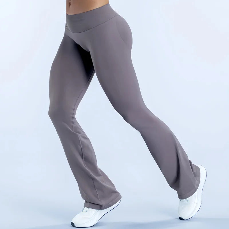 A person wearing seamless gray flared yoga leggings and white sneakers is shown in a side profile.