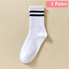 Une paire de chaussettes en tricot blanc avec trois rayures noires horizontales sur la cheville.