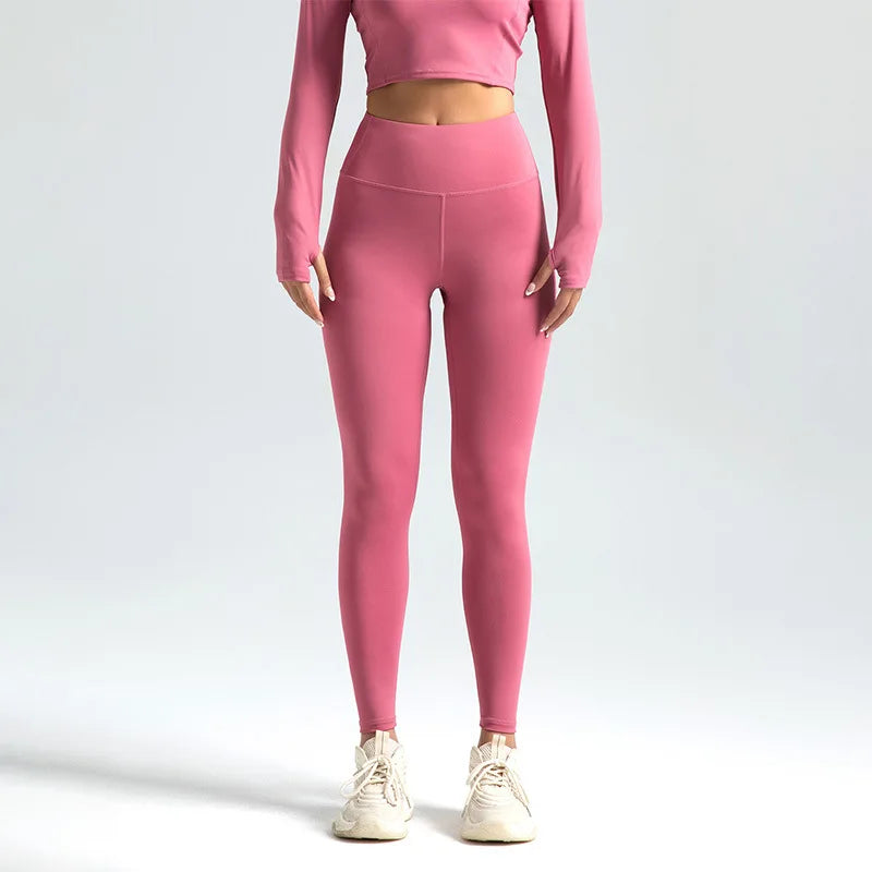 A model is wearing seamless high-waist yoga leggings in a dusty rose color.