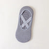 A pair of gray non-slip yoga and gym socks with a silicone grip pattern on the sole.