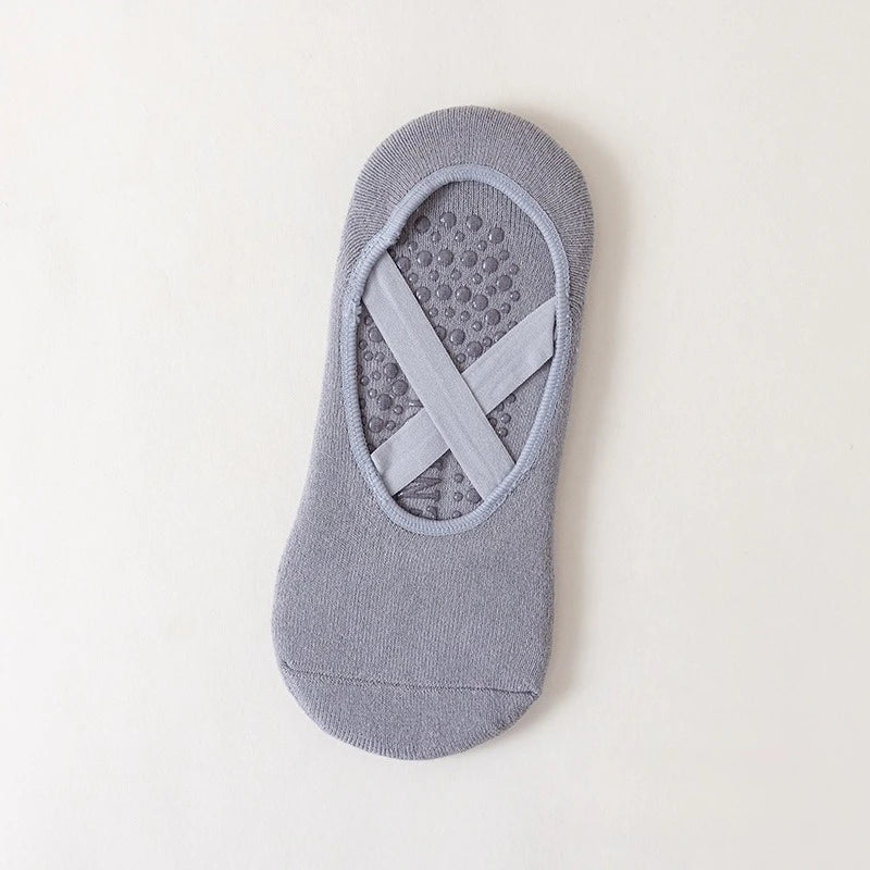 A pair of gray non-slip yoga and gym socks with a silicone grip pattern on the sole.