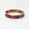 A silicone wristband with a marbled purple and yellow design featuring the number 77.