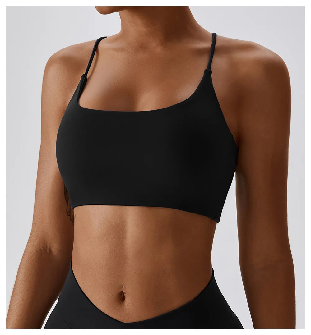 Una mujer vistiendo un sujetador deportivo en forma de U negro para fitness y yoga.