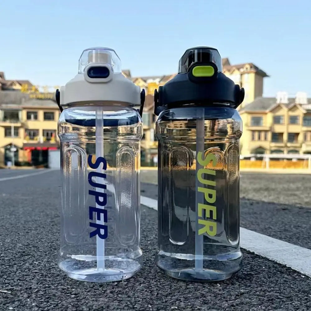 Two clear insulated sports water bottles with blue straws are placed on asphalt.