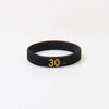 Black silicone wristband with the number 30 embossed on the surface.