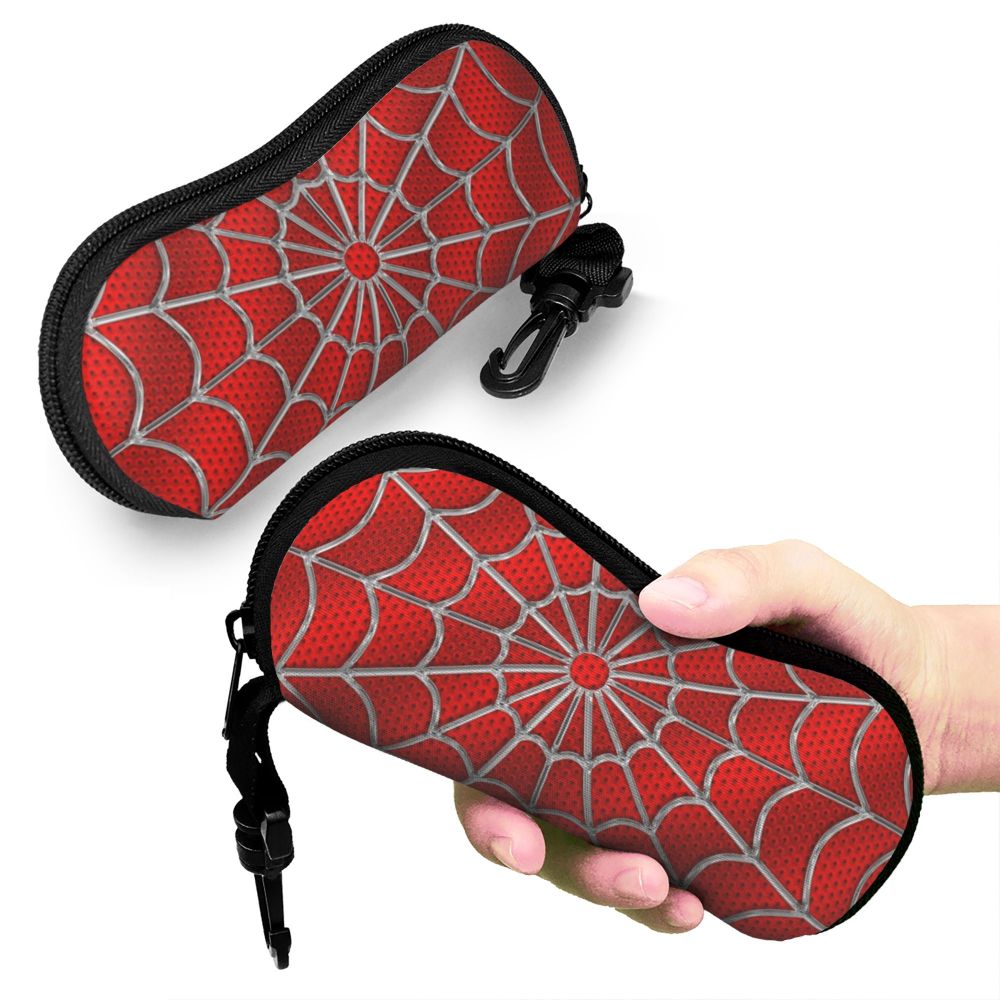 A red and gray spider web patterned eyeglass pouch being held by a hand.