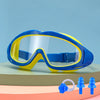 A pair of blue and yellow swimming goggles resting on a light green surface.
