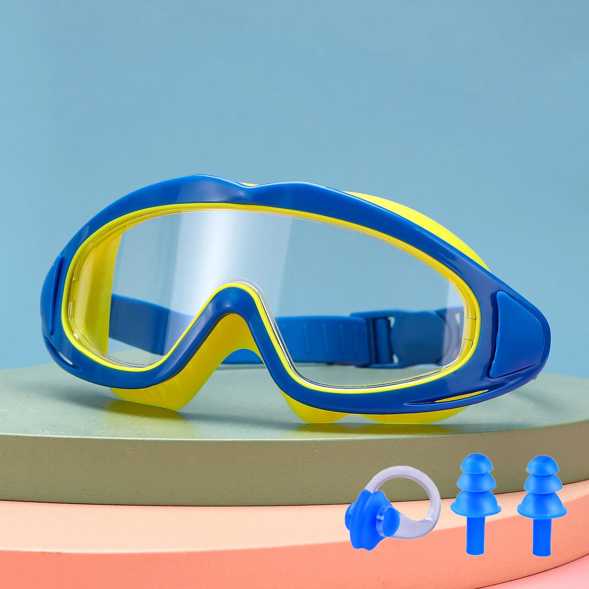 A pair of blue and yellow swimming goggles resting on a light green surface.