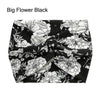 Bandeau en tissu noir avec motif floral blanc et feuilles vertes.