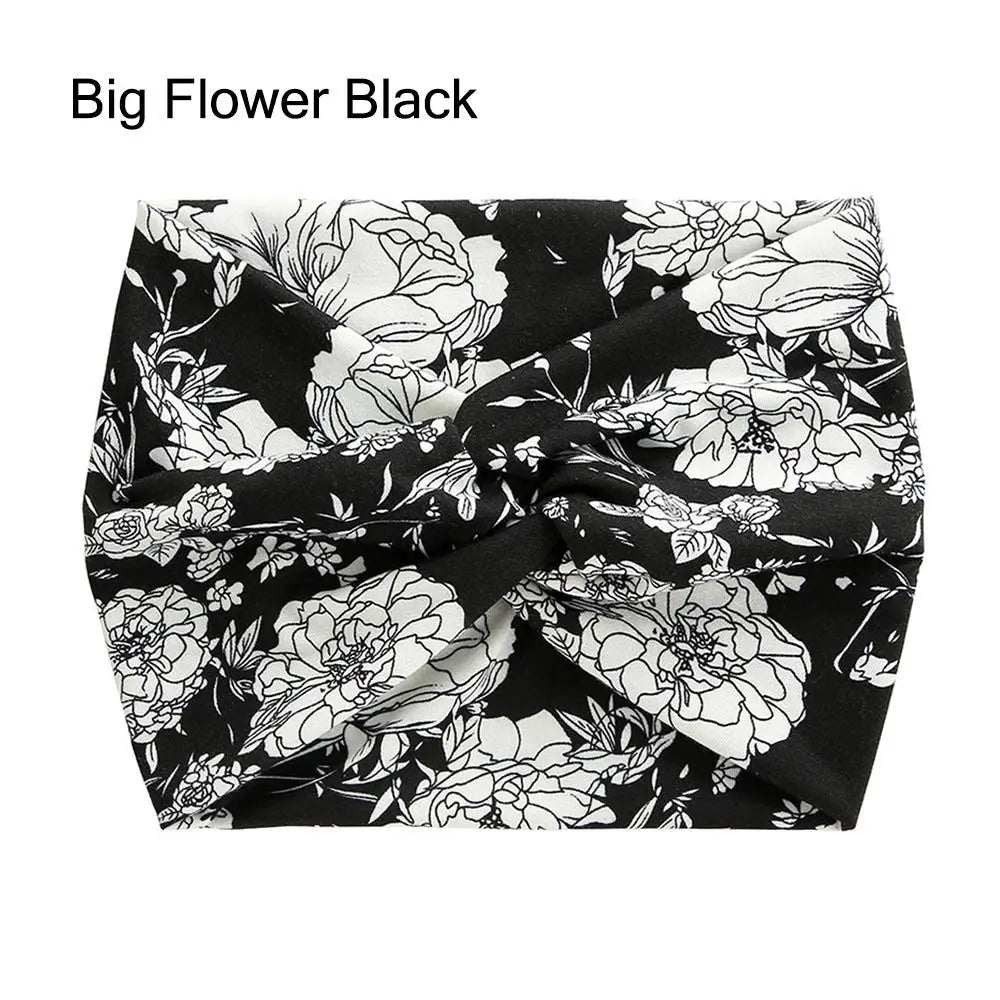Bandeau en tissu noir avec motif floral blanc et feuilles vertes.