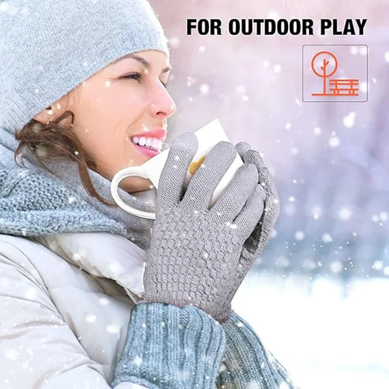 A woman wearing insulated winter gloves is holding a cup outdoors in the snow.