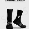 Ein Paar schwarze Fußballsocken mit weißem Kreuzdesign vor hellem grauem Hintergrund.