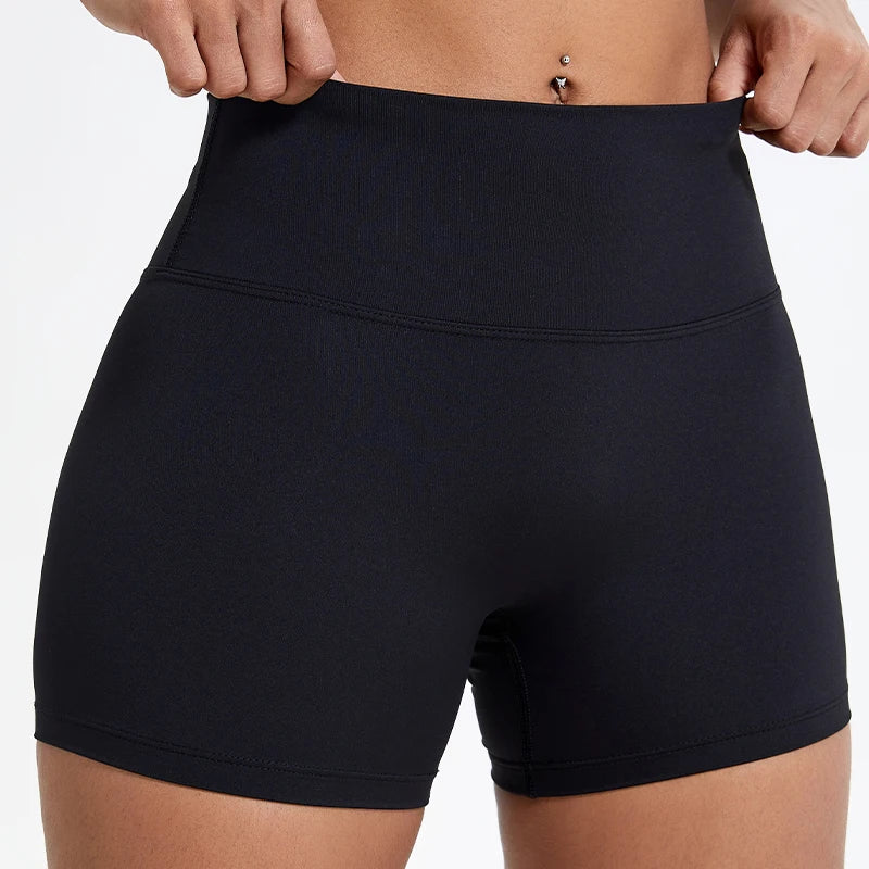 Shorts de yoga et de sport noirs taille haute compressifs portés par une personne.