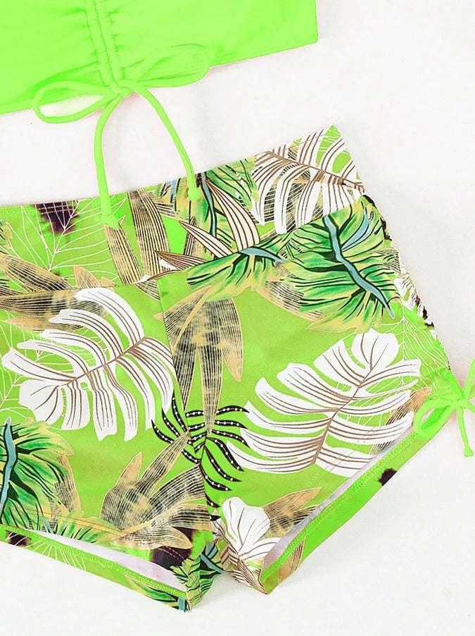 A bright lime green floral print two-piece high-waist bikini set with tropical leaves.