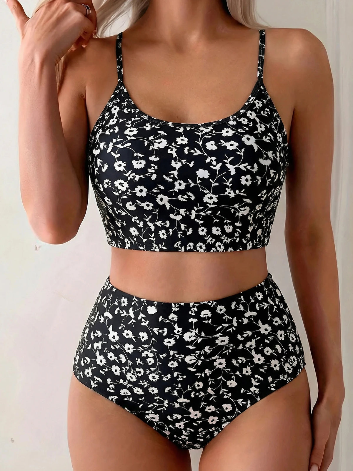 Modelo vistiendo un conjunto bikini de dos piezas estampado floral negro de cintura alta.