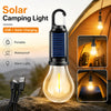A black solar camping light with a clear bulb is shown on a rock, demonstrating its portable and waterproof features.