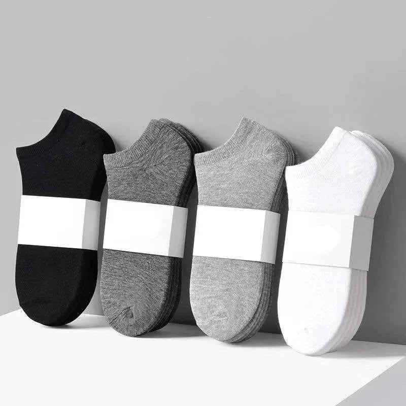 Un set de tres calcetines unisex de algodón transpirable en negro, gris y blanco.