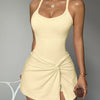 Model in a light yellow tennis skort dress with crisscross straps and matching top.