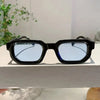 Black rectangular sunglasses with blue mirrored lenses resting on a white surface.