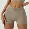 A model wearing high-waisted beige yoga and fitness leggings, showing the fit and details.