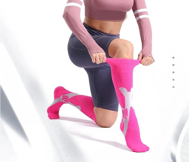 A person wearing pink compression socks on their feet while exercising or stretching.