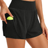 Eine Frau trägt schwarze, hochgeschnittene Sportshorts mit gelbem Taschendetail.
