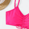 A bright pink two-piece bikini set with a tie-up top and bottoms is shown next to a straw hat.