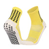 A pair of yellow and white performance sports grip socks shown from the side.
