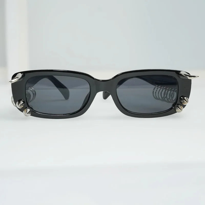 Black sunglasses with spiked rivets on the frame viewed from the front