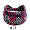 A patterned fabric turban headband featuring black, white, pink, and blue geometric designs.