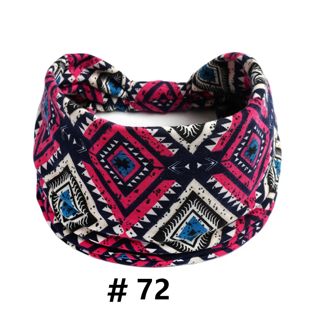A patterned fabric turban headband featuring black, white, pink, and blue geometric designs.