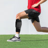 A person wearing a black calf compression brace while exercising on a green field.
