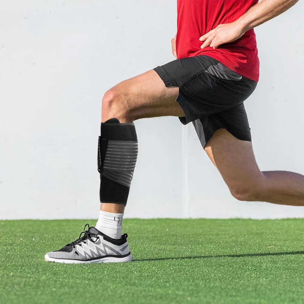 A person wearing a black calf compression brace while exercising on a green field.