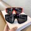 A pair of red and black cycling sunglasses resting on a white book.