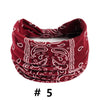 A close-up of a deep red boho print cotton bandana or scarf with white paisley patterns.