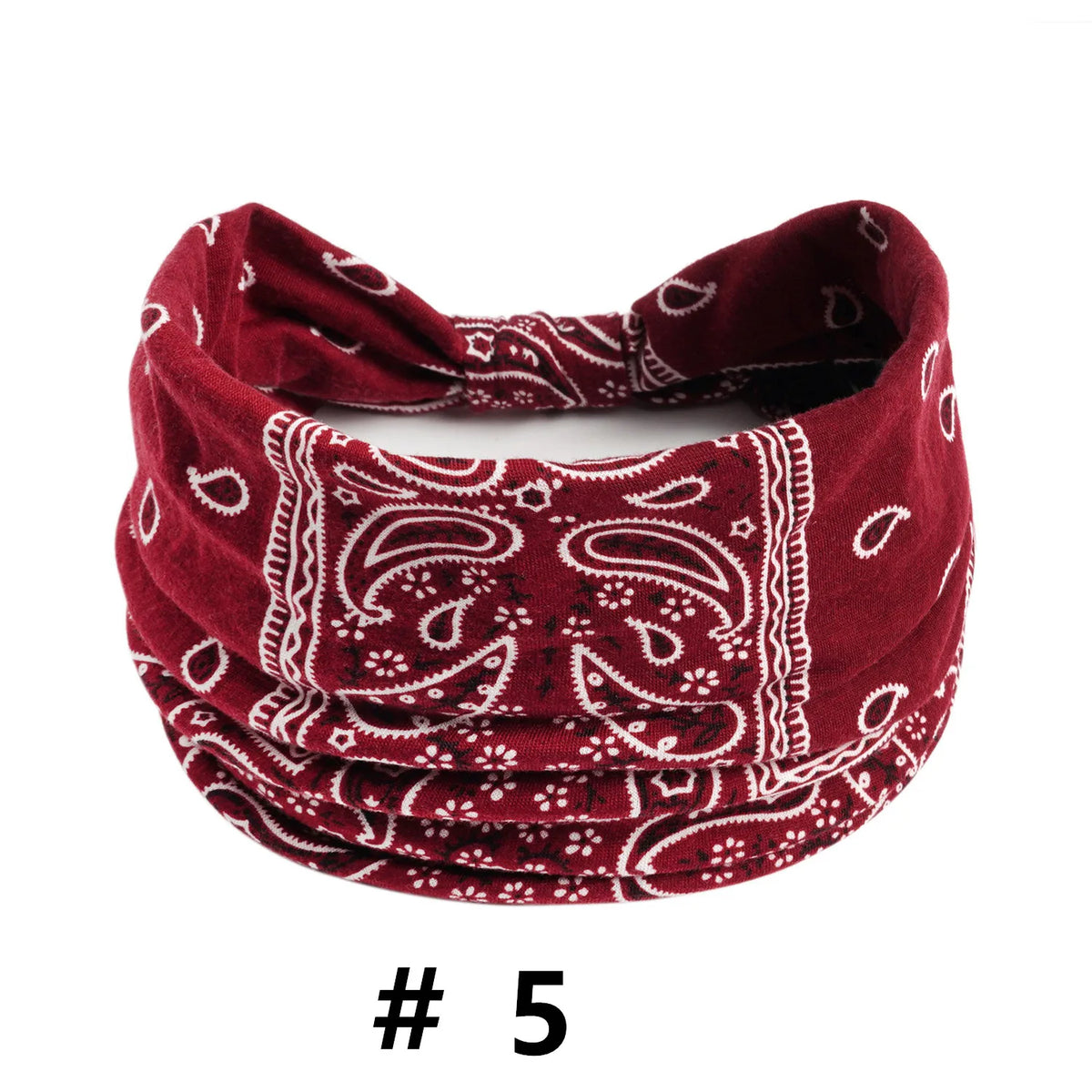 A close-up of a deep red boho print cotton bandana or scarf with white paisley patterns.