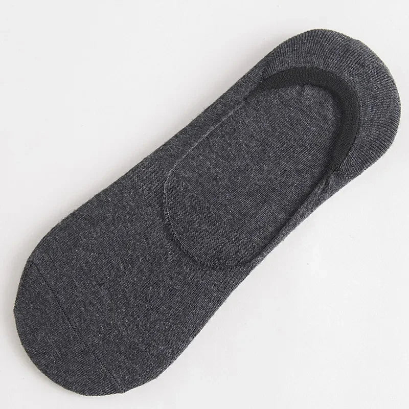 Une paire de chaussettes invisibles en silicone gris foncé et respirantes, posées à plat.