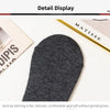 Gros plan d'une chaussette tricotée gris foncé sur une surface blanche à côté d'une boîte de produit Matisse.
