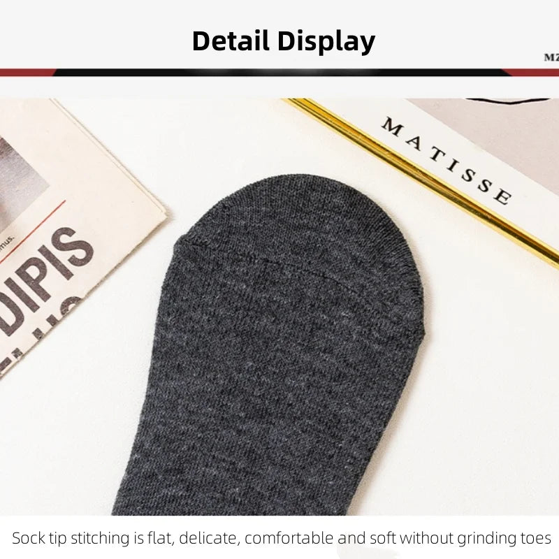 Gros plan d'une chaussette tricotée gris foncé sur une surface blanche à côté d'une boîte de produit Matisse.