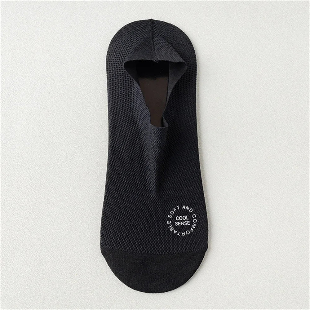 Chaussettes en maille antidérapantes noires pour hommes, vues à plat sur un fond clair.