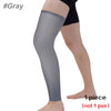 A full leg compression sleeve in gray worn on a person's leg.