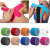 Various colors of kinesiology tape applied to a person's shoulder and arm for athletic recovery.